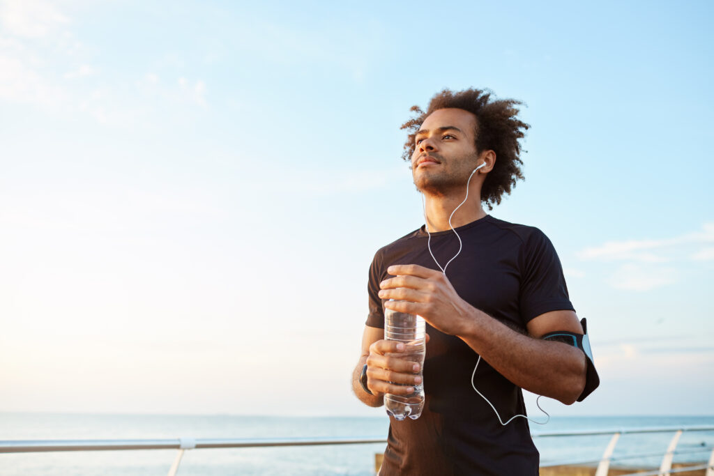 man-athlete-drinking-water-out-plastic-bottle-after-hard-running-workout-dark-skinned-male-sportsman-looking-sky-while-running-enjoying-view-1024x683 Hábito Saudável: Como Construir e Manter Com Sucesso