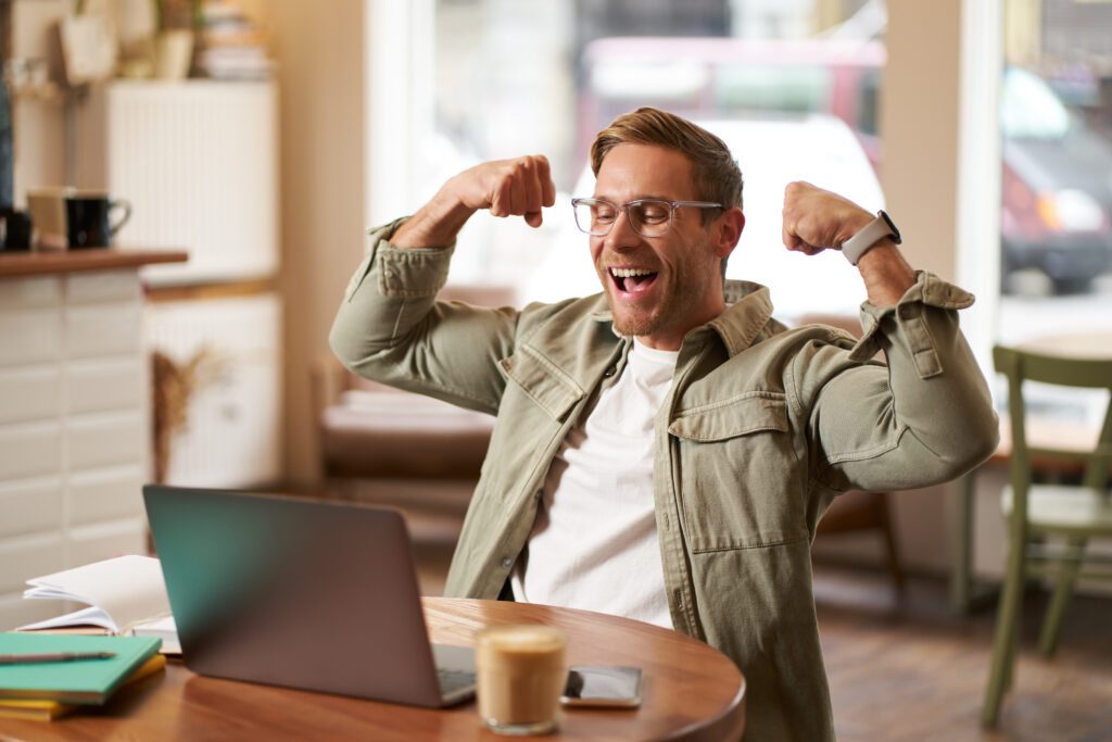 portrait-happy-young-man-glasses-rejoicing-sitting-cafe-watching-sports-game-laptop-1024x683 O Que é Impulsividade e Como Ela Afeta Seu Comportamento?