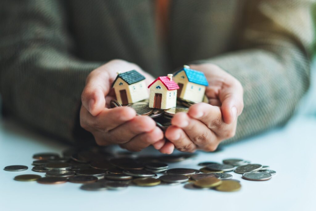 closeup-image-of-hands-holding-house-models-and-co-2022-10-06-22-11-25-utc-1024x683 Herança Essencial: Por Que Deixar Educação e um Lar Simples Já É o Suficiente