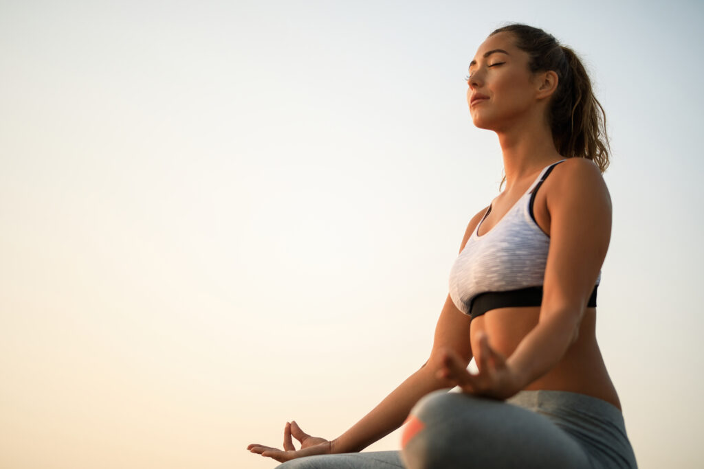 low-angle-view-woman-with-eyes-closed-practicing-yoga-against-sky-copy-space-1024x683 Como o Yoga Transforma a Saúde Mental: Reduza Ansiedade e Estresse Naturalmente