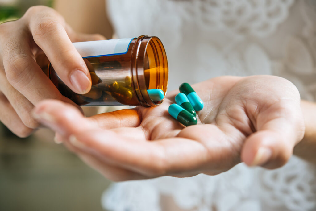 woman-s-hand-pours-medicine-pills-out-bottle-1024x684 Medicamentos para Insônia: Opções e Cuidados com Dependência