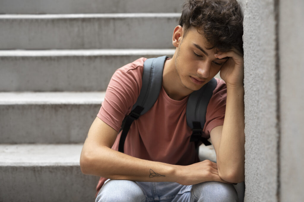 front-view-sad-boy-sitting-stairs-1-1024x683 Crise dos 20 Anos: Entenda as Causas, Sintomas e Caminhos para Superar Essa Fase