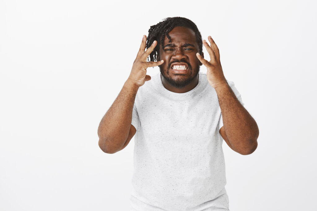 portrait-angry-guy-with-braids-posing-against-white-wall-1024x683 Raiva Contida: Os Impactos Psicológicos de Reprimir Emoções Negativas