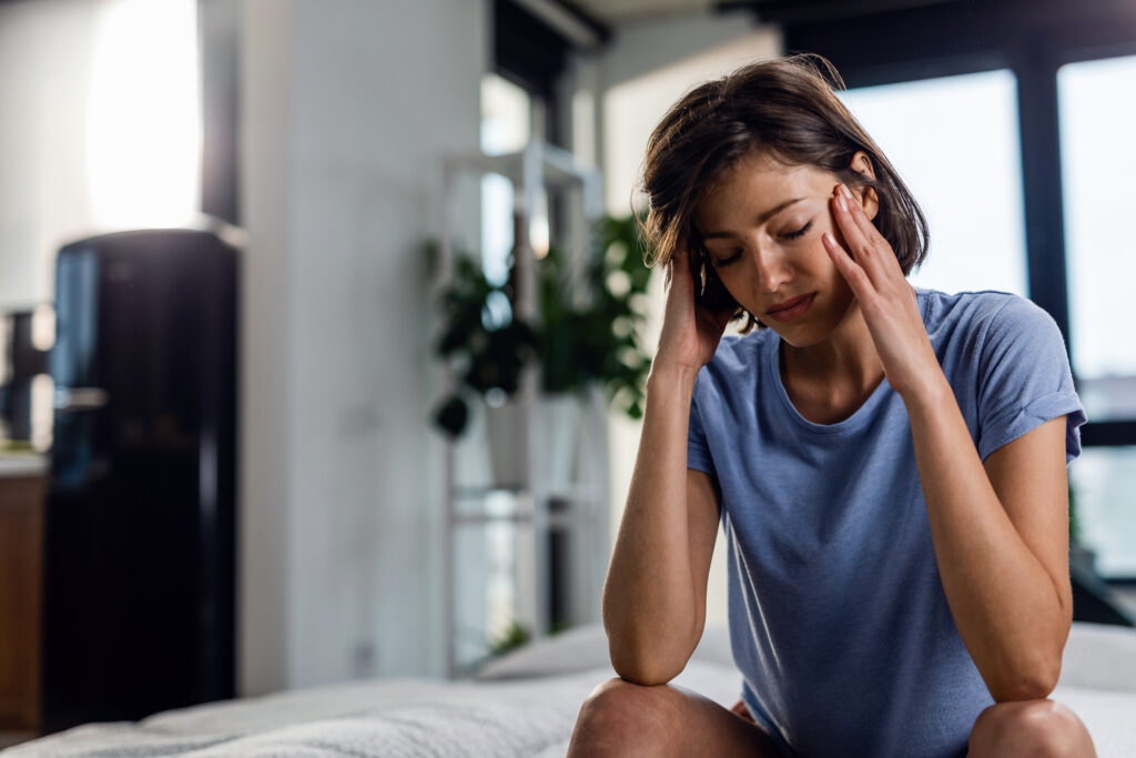 sad-woman-suffering-from-headache-sitting-bed-with-eyes-closed-while-holding-her-head-pain-1-1024x683 Cansaço Mental vs. Depressão: Diferenças, Sintomas e Novos Tratamentos Baseados em Evidências