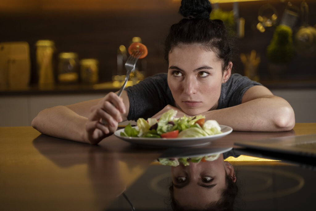 woman-trying-eat-healthy-home-1024x683 Transtornos Alimentares e Pressão Social: Como a Sociedade Influencia a Saúde Mental e Novas Estratégias de Tratamento