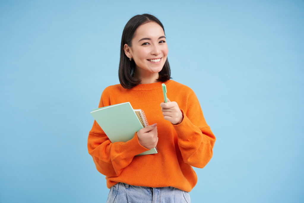 education-students-happy-asian-woman-holding-notebooks-laughing-smiling-camera-enjoys-goi-1024x683 Projeto de Vida e Saúde Mental dos Estudantes: Como Planejar o Futuro e Cuidar da Mente Caminham Juntos